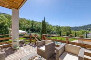 a patio with chairs and a table on a wooden deck at Maison de village in La Tour-sur-Orb