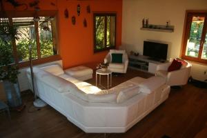 a living room with a large white couch and chairs at Le Loft House Jaun in Im Fang
