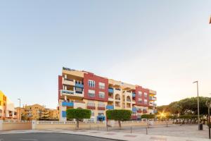 a building with colorful apartments in a parking lot at Piso a 200 metros de la playa in Roquetas de Mar