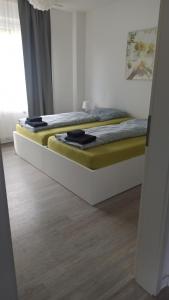 two twin beds in a room with a wooden floor at Helle Ferienwohnung an der Rheinpromenade 50 qm in Duisburg