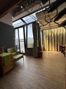 梅山鄉的住宿－阿漢的家民宿，客厅设有绿色沙发和大窗户
