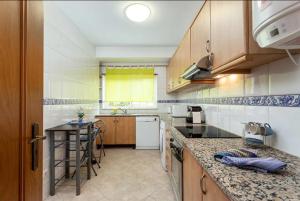 a kitchen with wooden cabinets and a counter top at Blife Candya private rooms in Faro