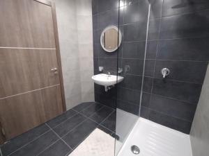 La salle de bains est pourvue d'un lavabo et d'une douche avec un miroir. dans l'établissement San Pawl Lodge, à San Pawl il-Baħar