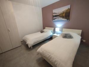 - une chambre avec deux lits et une lampe dans l'établissement San Pawl Lodge, à San Pawl il-Baħar