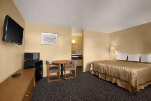 a hotel room with a bed and a flat screen tv at Travelodge by Wyndham Wenatchee in Wenatchee