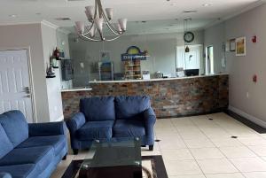 a living room with two blue couches and a kitchen at Days Inn by Wyndham Humble/Houston Intercontinental Airport in Humble