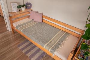 a bed with a wooden frame with a purple pillow at Heart of Mitau in Jelgava