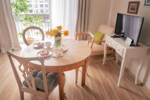 a living room with a table and a television at Heart of Mitau in Jelgava