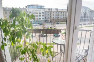 a balcony with a table and a view of a street at Heart of Mitau in Jelgava