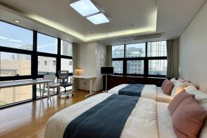 a bedroom with two beds and a desk and windows at COEX VIP 15 New Open [2 Queen beds] in Seoul