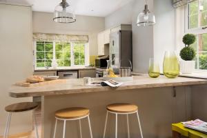 a kitchen with a large counter with stools at Lane Cottage in Coldstream
