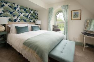 a bedroom with a large bed and a window at Lane Cottage in Coldstream