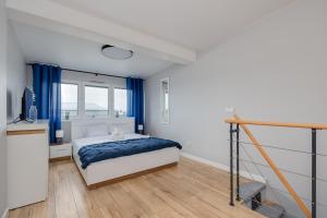 1 dormitorio con 1 cama y cortinas azules en Flaminga Two-Level Apartment, en Szczecin