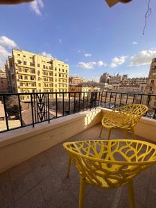 two yellow chairs and a table on a balcony at Economy room in Downtown in Cairo
