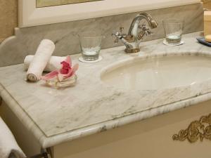 Hotel Le Royal Lyon - MGallery في ليون: منضدة الحمام مع الحوض والمنشفة