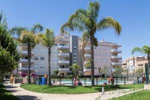 un complejo con piscina y palmeras en Atico Canet, en Canet de Berenguer