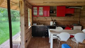 cocina con armarios rojos, mesa y sillas en Oandu Camping en Oandu