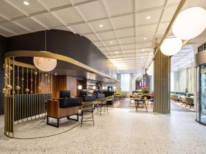 a lobby of a hotel with chairs and tables at Pullman Stuttgart Fontana in Stuttgart