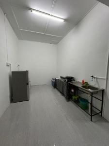 an empty room with a white wall and a table at RumaDino Homestay in Melaka