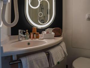 y baño con lavabo y espejo. en ibis Bayeux Port En Bessin en Port-en-Bessin-Huppain