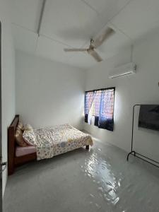 a bedroom with a bed in a room with a window at RumaDino Homestay in Melaka