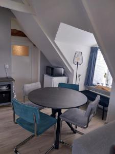 uma cozinha com mesa e cadeiras num quarto em De Posthoorn em Appelscha