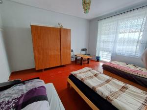 1 dormitorio con 2 camas, armario y ventana en Noclegi nad S-ką, en Miechów