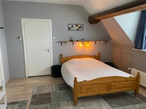 een slaapkamer met een houten bed op zolder bij De Posthoorn in Appelscha