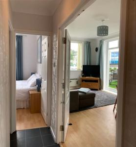 a bedroom with a bed and a living room with a couch at SHOREBANKS - Harbour View Apartment in Sandbanks. in Sandbanks