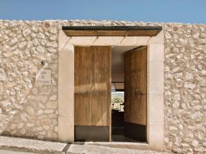 a door in a stone building with a sign on it at Finca Serena Mallorca, Small Luxury Hotels in Montuiri