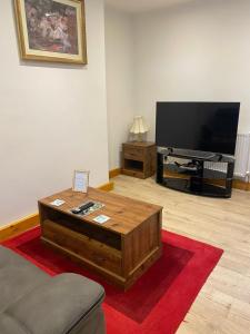 a living room with a coffee table and a flat screen tv at The Cellar on Hornby in Morecambe