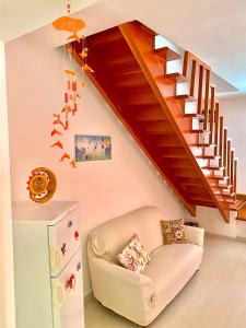 ein Wohnzimmer mit einem Stuhl und einer Treppe in der Unterkunft Casa Vacanza Mare Blu in Villaggio Azzurro