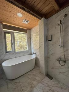 梅山鄉的住宿－阿漢的家民宿，带窗户的浴室内的白色浴缸