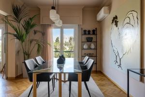 une salle à manger avec une table et des chaises en verre dans l'établissement Stylish flat overlooking the temple of Zeus, à Athènes