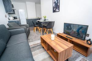 a living room with a couch and a tv and a table at Bright and Modern 2 Bed Apartment in Redditch in Redditch