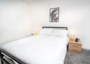 a bedroom with a large white bed and a night stand at Bright and Modern 2 Bed Apartment in Redditch in Redditch