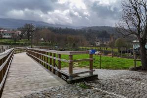 uma ponte pedonal de madeira com vista para um parque em Casa da Ecovia em Arouca