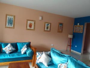 una sala de estar con sofás azules en una habitación en Nightingale Apartments Hotel Mombasa, en Shanzu