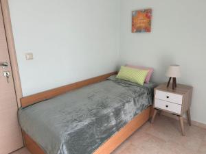 a small bedroom with a bed and a night stand at Villa Platania in Palaiokómi