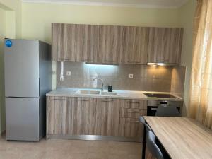 a kitchen with wooden cabinets and a white refrigerator at Villa Platania in Palaiokómi