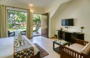 Hridey Retreat Resort في رامناجار: غرفة معيشة مع أريكة وتلفزيون