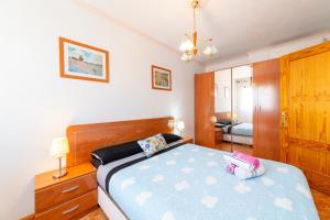 - une chambre avec un lit et une couette bleue dans l'établissement Edificio Merlin, à Roquetas de Mar