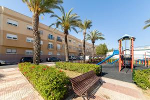 un parc avec une aire de jeux et un toboggan dans l'établissement Edificio Merlin, à Roquetas de Mar