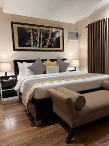 1 dormitorio con 1 cama grande y 1 sofá en Subic Residencias, en Olóngapo