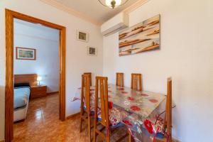 a dining room with a table and a bedroom at Edificio Merlin in Roquetas de Mar