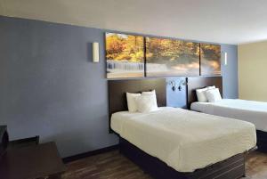 um quarto de hotel com duas camas e duas janelas em Days Inn by Wyndham New Orleans Pontchartrain em Nova Orleães