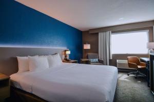 ein Hotelzimmer mit einem weißen Bett und einer blauen Wand in der Unterkunft Comfort Inn & Suites Moreno Valley near March Air Reserve Base in Moreno Valley