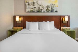 una camera da letto con un grande letto bianco con due comodini di Comfort Inn Fredericton a Fredericton
