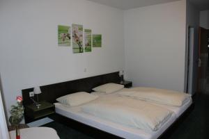 ein Bett mit zwei Kissen auf einem Zimmer in der Unterkunft Gasthof Krone in Schuttertal