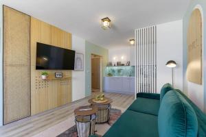 een woonkamer met een groene bank en een tv bij Mare Vista Suite in Varna